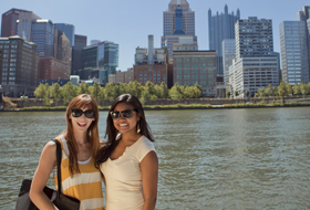 Two La Roche University students in front of the Pittsburgh skyline